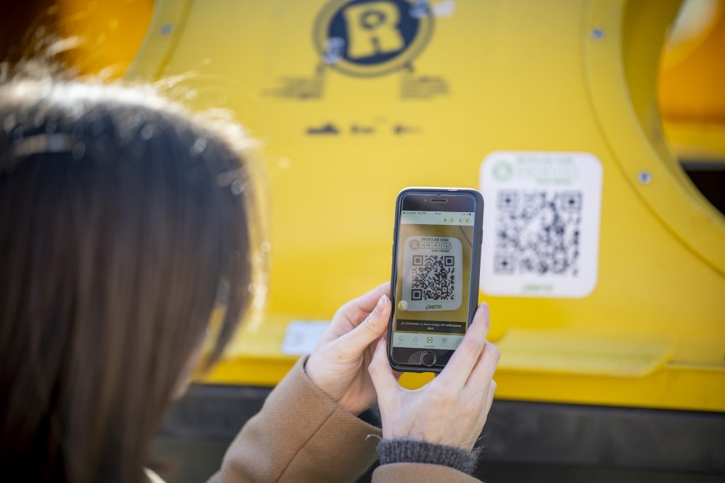 Una persona utiliza en su móvil la app de reciclaje incentivado de RECICLOS